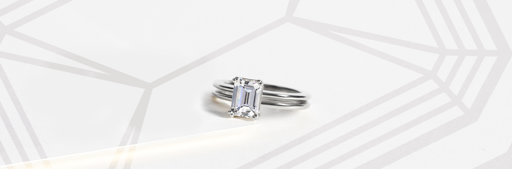 An engagement ring featuring an emerald cut center stone