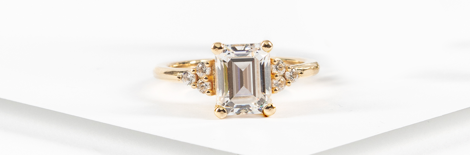 an engagement ring featuring an emerald cut center stone