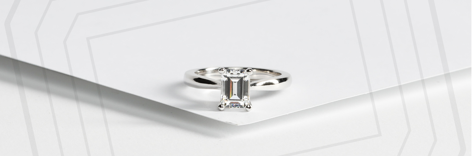 an emerald cut stone with a silver solitaire setting