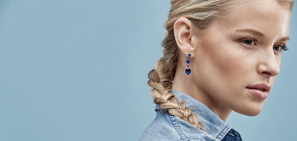 blue sapphire drop earrings on a woman