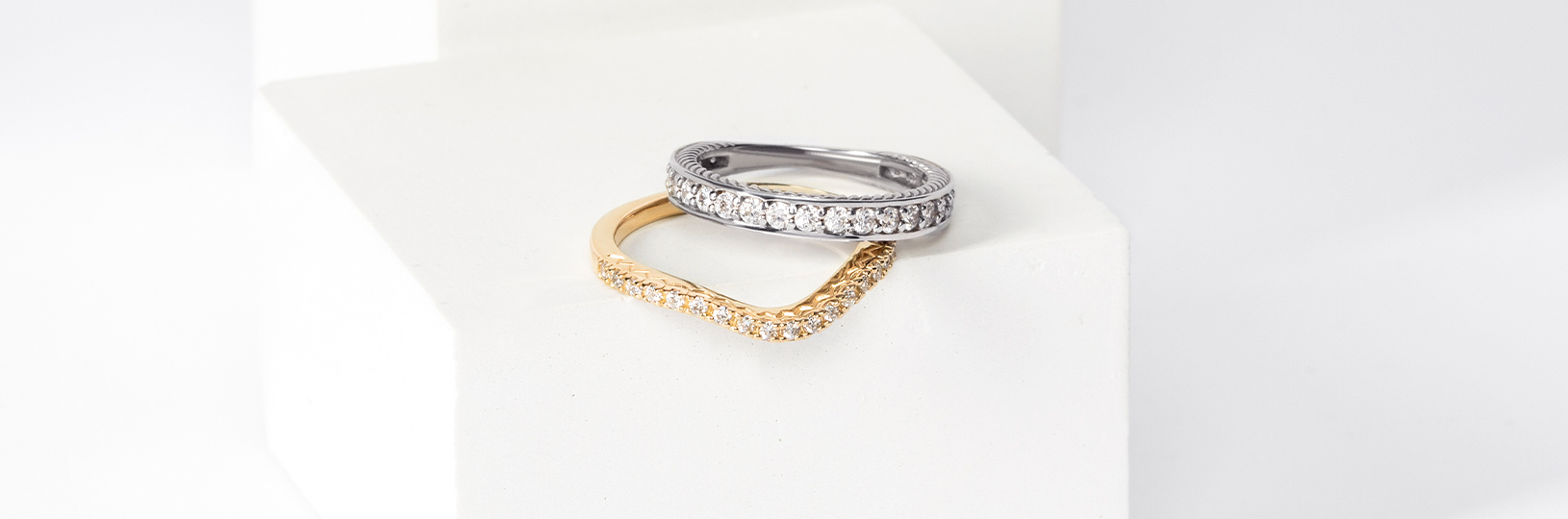 Two wedding bands, one in yellow gold, the other in white gold